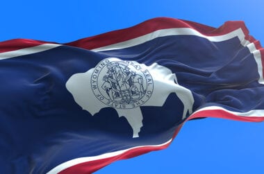 Wyoming state flag flying in a blue sky.