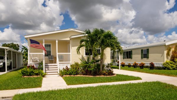mobile home manufactured home with palm trees and US flag.
